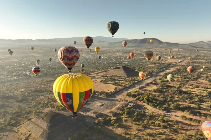 A yellow balloon drifting low over the plain near the pyramids